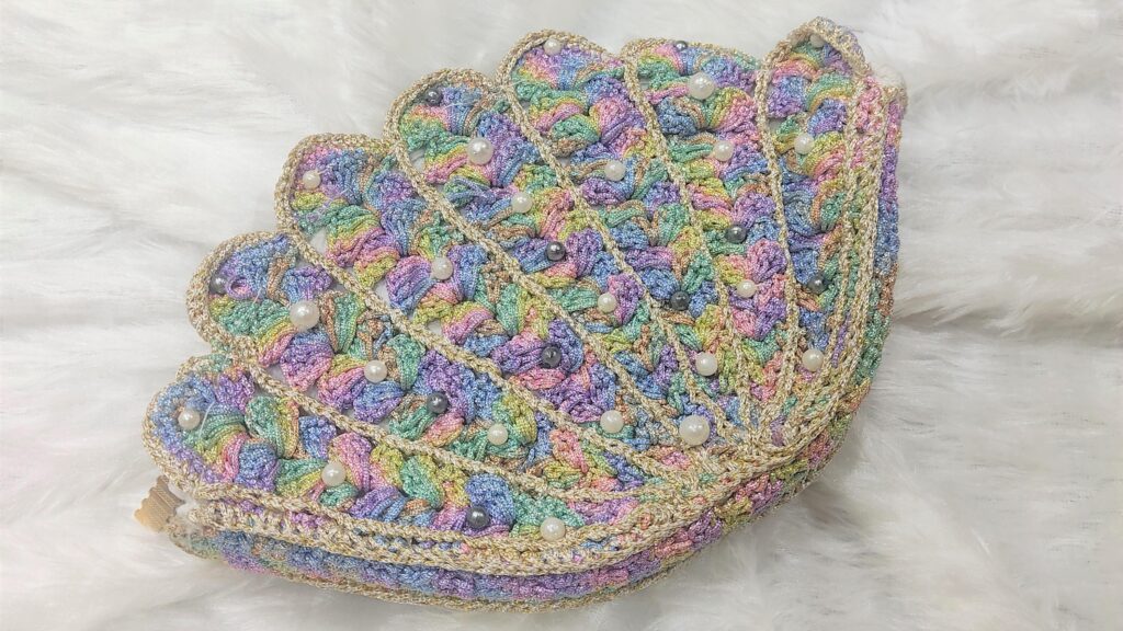 Handmade clutch bag, trendy crochet bags for women made of multi color yarn with pearl intricate in it.