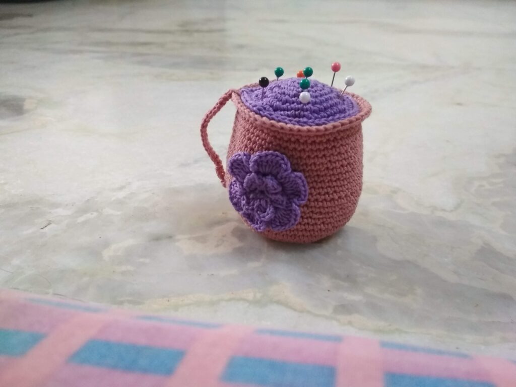 Pink amigurumi coffee mug can be used as pin holder